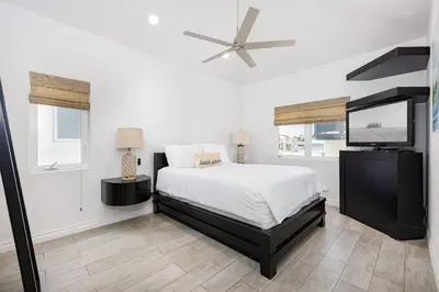 a bedroom with a bed and a flat screen tv at 204 E Oceanfront B in Newport Beach