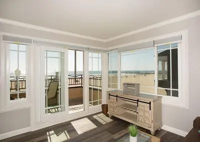 a living room with a room with windows and a desk at 2314 W Oceanfront A in Newport Beach