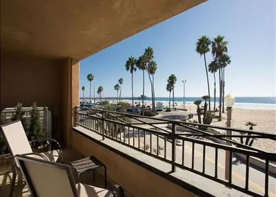 a balcony with a view of the beach and palm trees at 2314 W Oceanfront A in Newport Beach