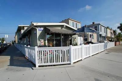 a building with a white fence and an umbrella at Lower West Newport in Newport Beach