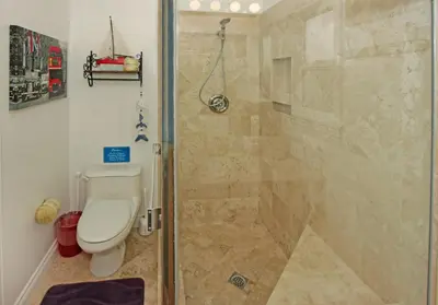 a bathroom with a toilet and a glass shower at Lower West Newport in Newport Beach