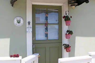 a green door with potted plants on it at Lower West Newport in Newport Beach