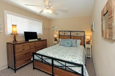 a bedroom with a bed and a ceiling fan at Lower West Newport in Newport Beach
