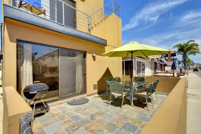 a patio with a table and chairs and an umbrella at 3 Bedrooms in Newport Beach
