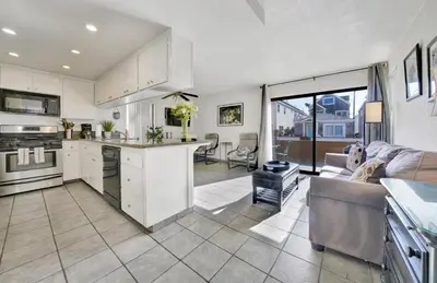 a kitchen and living room with white cabinets and a couch at 3 Bedrooms in Newport Beach