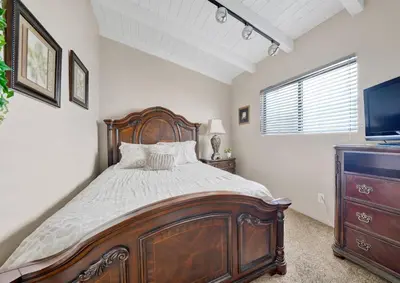 a bedroom with a wooden bed and a television at 4 Bedrooms in Newport Beach