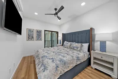 a bedroom with a bed and a ceiling fan at Rooftop Home With Ocean View & Private Parking in Oceanside