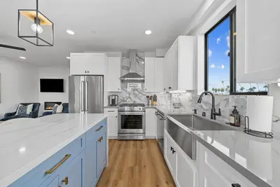a kitchen with white appliances and a large window at Rooftop Home With Ocean View & Private Parking in Oceanside