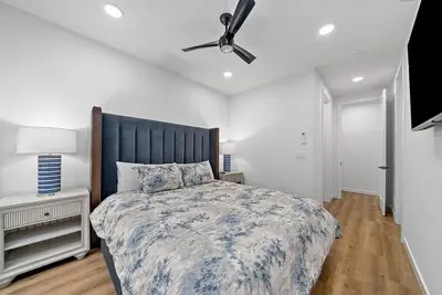 a bedroom with a large bed and a ceiling fan at Rooftop Home With Ocean View & Private Parking in Oceanside