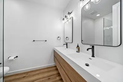 a white bathroom with a sink and a mirror at Rooftop Home With Ocean View & Private Parking in Oceanside