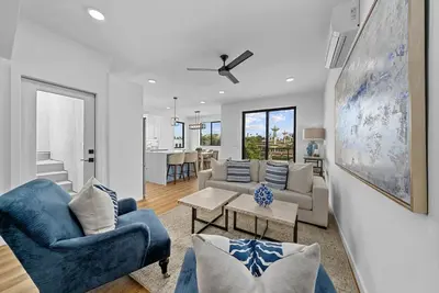 a living room with two blue chairs and a couch at Rooftop Home With Ocean View & Private Parking in Oceanside