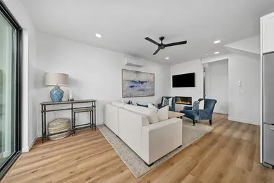 a living room with a white couch and a chair at Rooftop Home With Ocean View & Private Parking in Oceanside