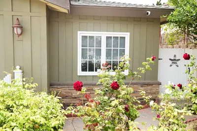 a house with a window and red flowers in front at PRIVATE La Jolla Guest Suite in San Diego