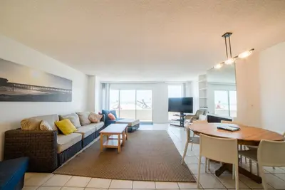 a living room with a couch and a table at Abigail - Beachfront in Newport Beach