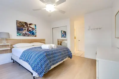 a bedroom with a bed and a ceiling fan at Beatrice - Beachfront in Newport Beach