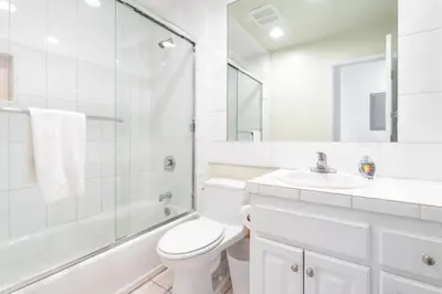 a white bathroom with a toilet and a sink at Beatrice - Beachfront in Newport Beach