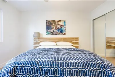 a blue and white bed in a white bedroom at Christina - Beachfront in Newport Beach