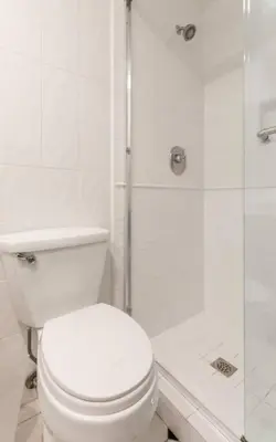a white bathroom with a toilet and a shower at Benjamin - Oceanview in Newport Beach