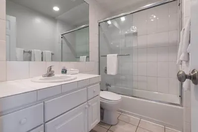 a white bathroom with a toilet and a shower at Christopher - Oceanview in Newport Beach