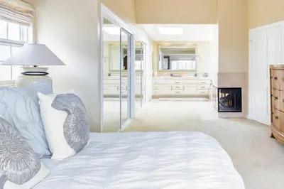 a living room with a bed and a fireplace at Beachfront Home in Newport Beach