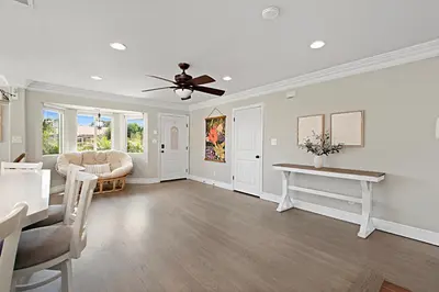 a living room with a ceiling fan and a table at The Gathering Place - Guest Favorite with Huge Yard in San Diego