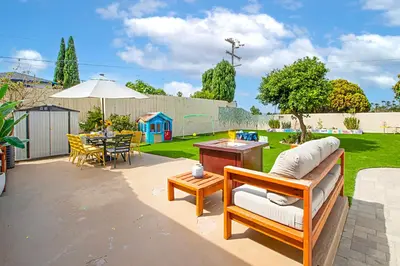 a patio with a couch and a table and a tableablish at The Gathering Place - Guest Favorite with Huge Yard in San Diego