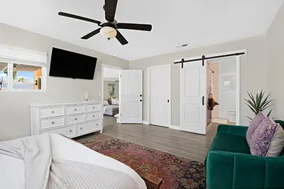 a living room with a bed and a ceiling fan at The Gathering Place - Guest Favorite with Huge Yard in San Diego
