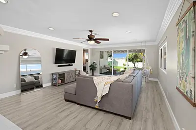 a living room with a couch and a ceiling fan at The Gathering Place - Guest Favorite with Huge Yard in San Diego