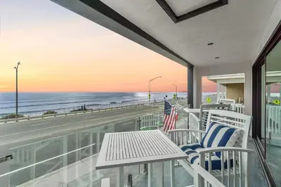 a balcony with a table and chairs and the beach at Private Beachside Home with HotTub in Carlsbad
