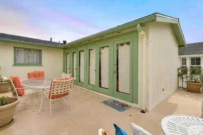 a green and white building with a table and chairs at 319 Coronado in Newport Beach