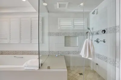a white bathroom with a shower and a sink at 3312 W Oceanfront in Newport Beach