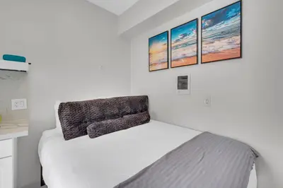 a bedroom with a bed with three pictures on the wall at The Shining Sea Crab in Oceanside