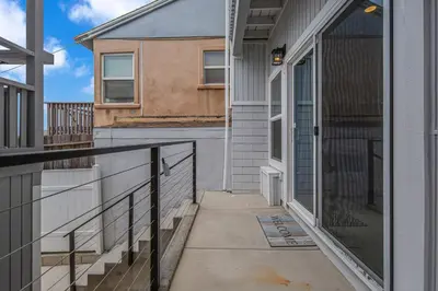 a balcony of a house with a door and a porch at The Shining Sea Crab in Oceanside