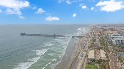 an aerial view of a beach with a pier at The Shining Sea Crab in Oceanside