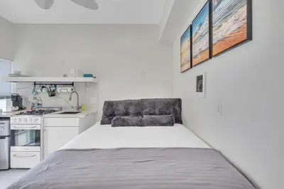 a small white kitchen with a bed in a room at The Shining Sea Crab in Oceanside