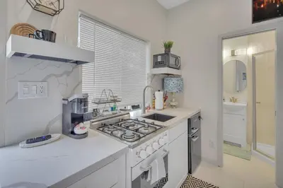 a white kitchen with a stove and a sink at The Shining Sea Octopus in Oceanside