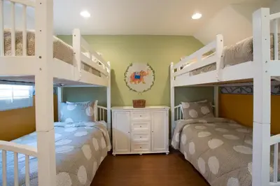 two bunk beds in a bedroom with yellow walls at 3600 W Oceanfront in Newport Beach