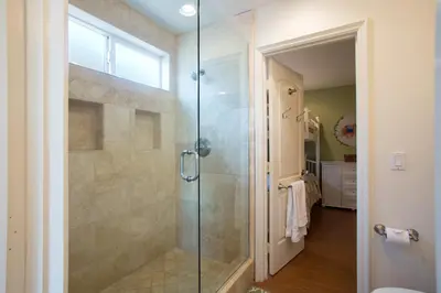 a bathroom with a shower with a glass door at 3600 W Oceanfront in Newport Beach