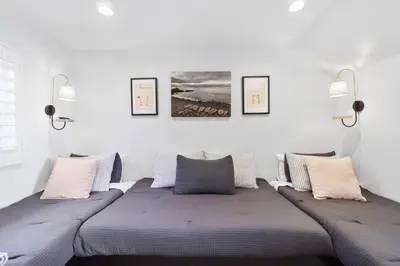 a bedroom with two beds and two pictures on the wall at 3600 W Oceanfront in Newport Beach