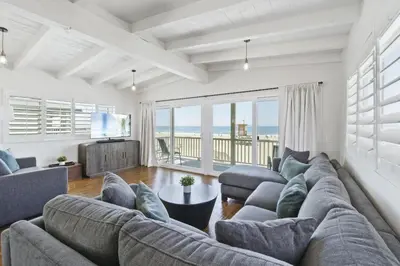 a living room with a large couch and a television at 3600 W Oceanfront in Newport Beach
