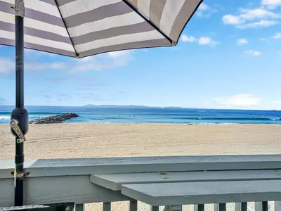 a beach with a bench and an umbrella at 3607 Seashore Dr B in Newport Beach