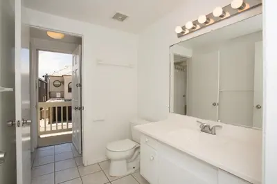 a white bathroom with a toilet and a mirror at 3612 Seashore Dr in Newport Beach