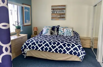 a bedroom with a bed with a blue and white comforter at 4210 Seashore Dr in Newport Beach