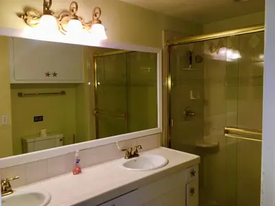 a bathroom with two sinks and a shower with a mirror at 4212 Seashore Dr A in Newport Beach