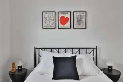 a bedroom with a bed with three pictures on the wall at Bungalow near zoo and beach with AC, EV, private yard in San Diego