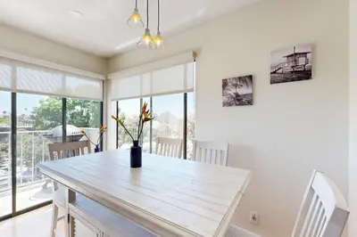 a dining room with a table with a vase on it at Tranquil Escape Bayside in San Diego