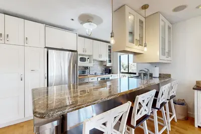a kitchen with white cabinets and a large counter top at Tranquil Escape Bayside in San Diego