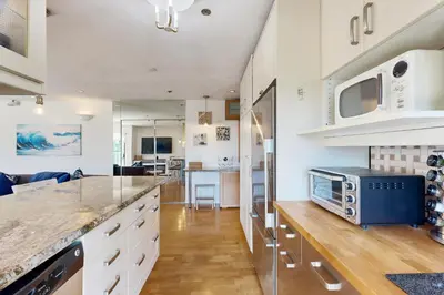 a kitchen with white cabinets and a counter top at Tranquil Escape Bayside in San Diego