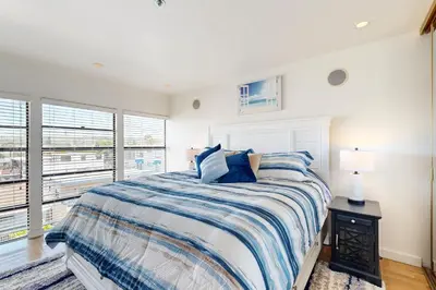 a white bedroom with a bed and a window at Tranquil Escape Bayside in San Diego
