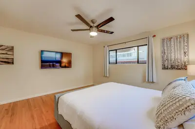 a bedroom with a white bed and a ceiling fan at Sail Bay Dream - Steps to the bay! in San Diego